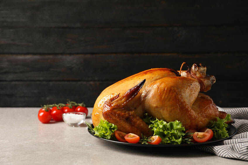 Platter of cooked turkey with garnish on table. Space for text